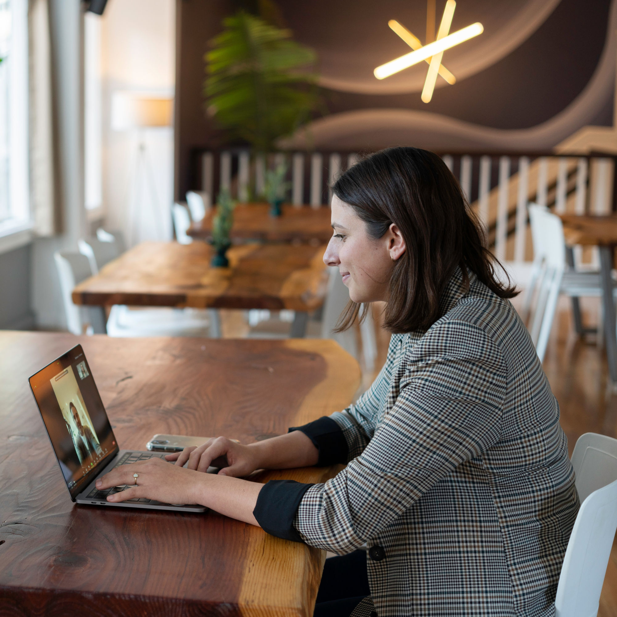Image of a woman in professional attire having a virtual conversation with someone on her laptop for the blog "Both Interview Skills and Cultural Competence Are Needed in a Tight Labor Market"