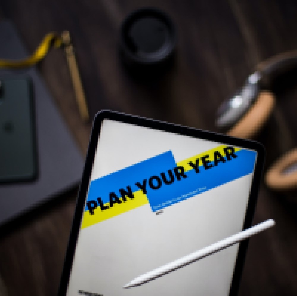 Image of a black tablet with the words "Plan Your Year" displayed for the blog "What Are Your Hiring Goals for 2024 and How Diverse, Inclusive and Equitable is Your Hiring Process?"